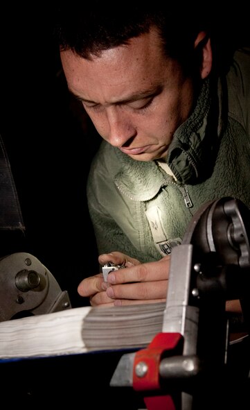 YOKOTA AIR BASE, Japan -- Senior Airman Evan Owens, 374th Aircraft Maintenance Squadron crewchief, inspects a light bulb at Yokota Air Base, Japan, Oct. 29, 2012. Owens used a technical order to verify the condition of the light bulb while changing the cargo dome light, a job that's required every 20 flights.  (U.S. Air Force photo by Airman 1st Class Krystal M. Garrett)