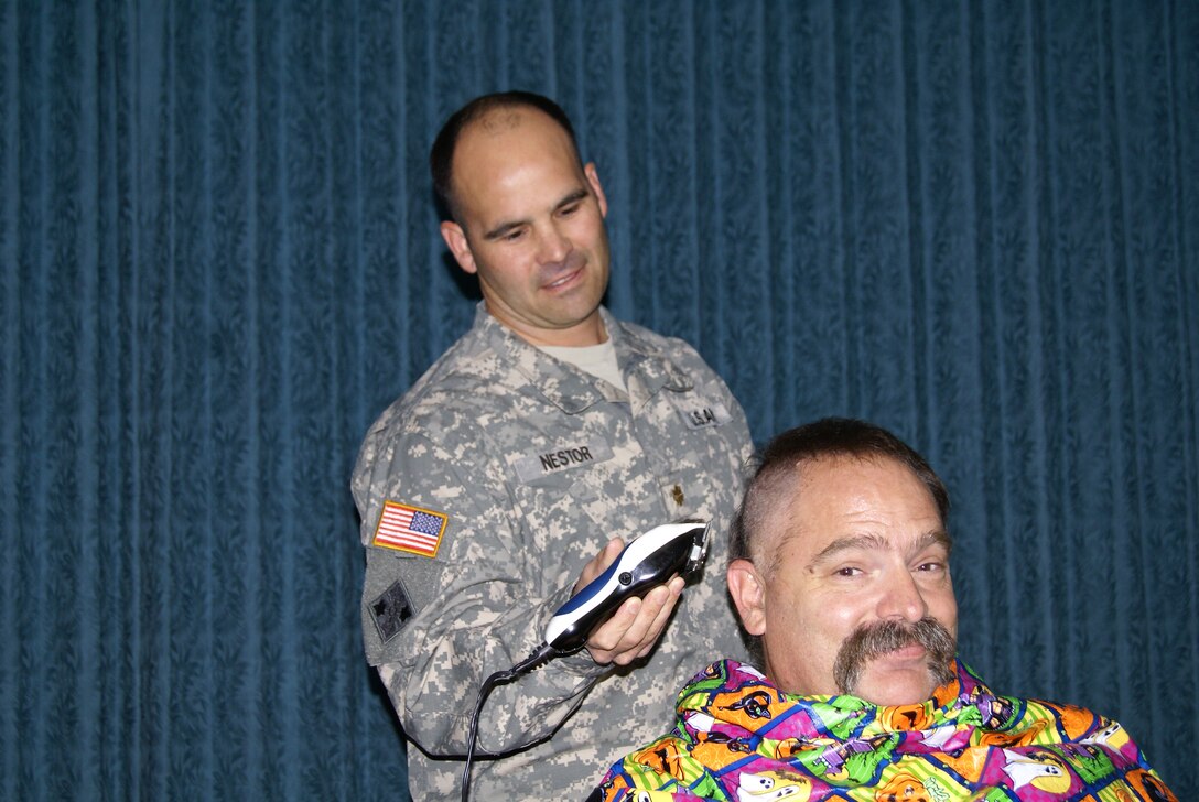 Geza Horvath, Emergency Management Office, has his head shaved by Maj. Don Nestor, Tulsa District deputy commander. Geza and employee Brandon Ellis offered to shave their heads if they each received $100 in donations for the Combined Federal Campaign. 