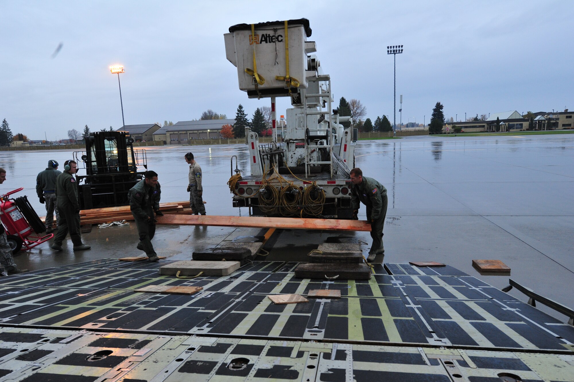 Staff Sgt. Saul Buenrostro, left, and Master Sgt. Jason Nipar, both C-5 loadmasters, 60th Airlift Wing, Travis Air Force Base, Calif., lay the first board down to enhance the ramp of the C-5 on the Fairchild AFB flightline Nov. 3. Two of the largest utility vehicles weighed about 50,000 pounds and were more than 35 feet in length. A wooden ramp allowed these larger vehicles to enter the aircraft at a shallower angle. The C-5 departed with 19 BPA employee volunteers and five of their 14 vehicles at about 11 a.m. for Joint Base McGuire Dix Lakehurst. The rest of the vehicles are being flown to the East Coast by two C-17 Globemasters assigned to Joint Base Charleston, S.C. BPA will make their way to Long Island, New York to help restore power that was knocked out by Hurricane Sandy. (U.S. Air Force photo by Airman 1st Class Taylor Curry)