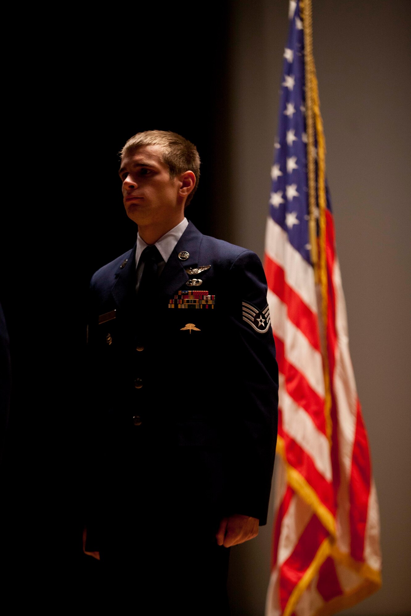 Staff Sgt. Aaron Parcha stands at attention during his Distinguished Flying Cross with Valor Medal presentation during a ceremony at the Talkeetna Theater on Joint Base Elmendorf-Richardson Nov. 3.  Parcha exposed himself to enemy fire to ensure casualties were treated and safely returned to base during Operation Bulldog Bite November 2010. Photo by Lt. Bernie Kale, Alaska National Guard Public Affairs Office