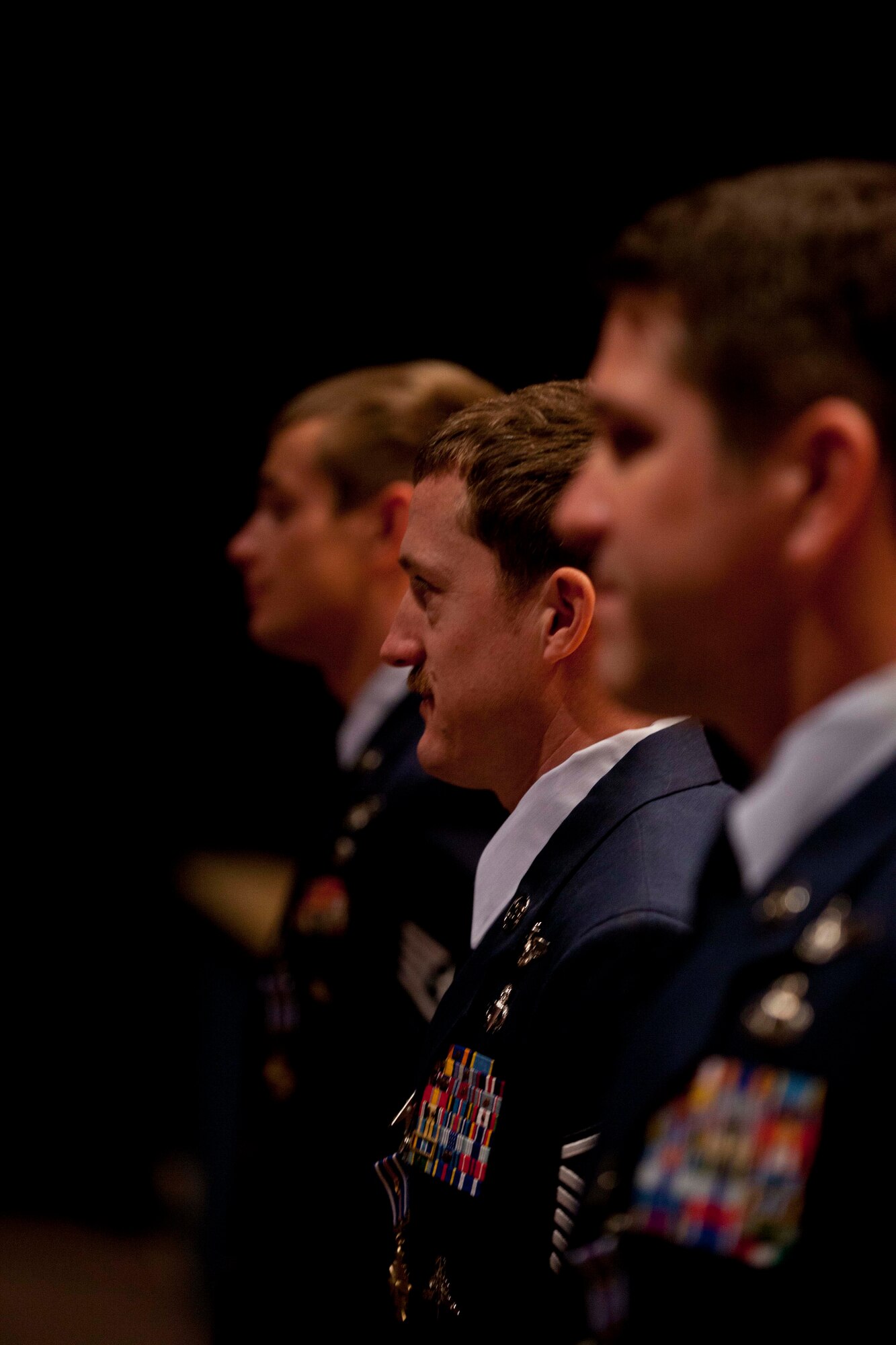 Master Sgt. Brandon Stuemke (center), Senior Master Sgt. Christopher “Doug” Widener (left) and Staff Sgt. Aaron Parcha wait to shake hands with the hundreds of attendees to the Distinguished Flying Cross with Valor Medal presentation at the Talkeetna Theater on Joint Base Elmendorf-Richardson Nov. 3.. The three pararescuemen from the 212th Rescue Squadron conducted more than 20 missions in 5 days, including treating a fellow pararescueman from a gunshot wound while under enemy fire. Photo by Lt. Bernie Kale, Alaska National Guard Public Affairs Office