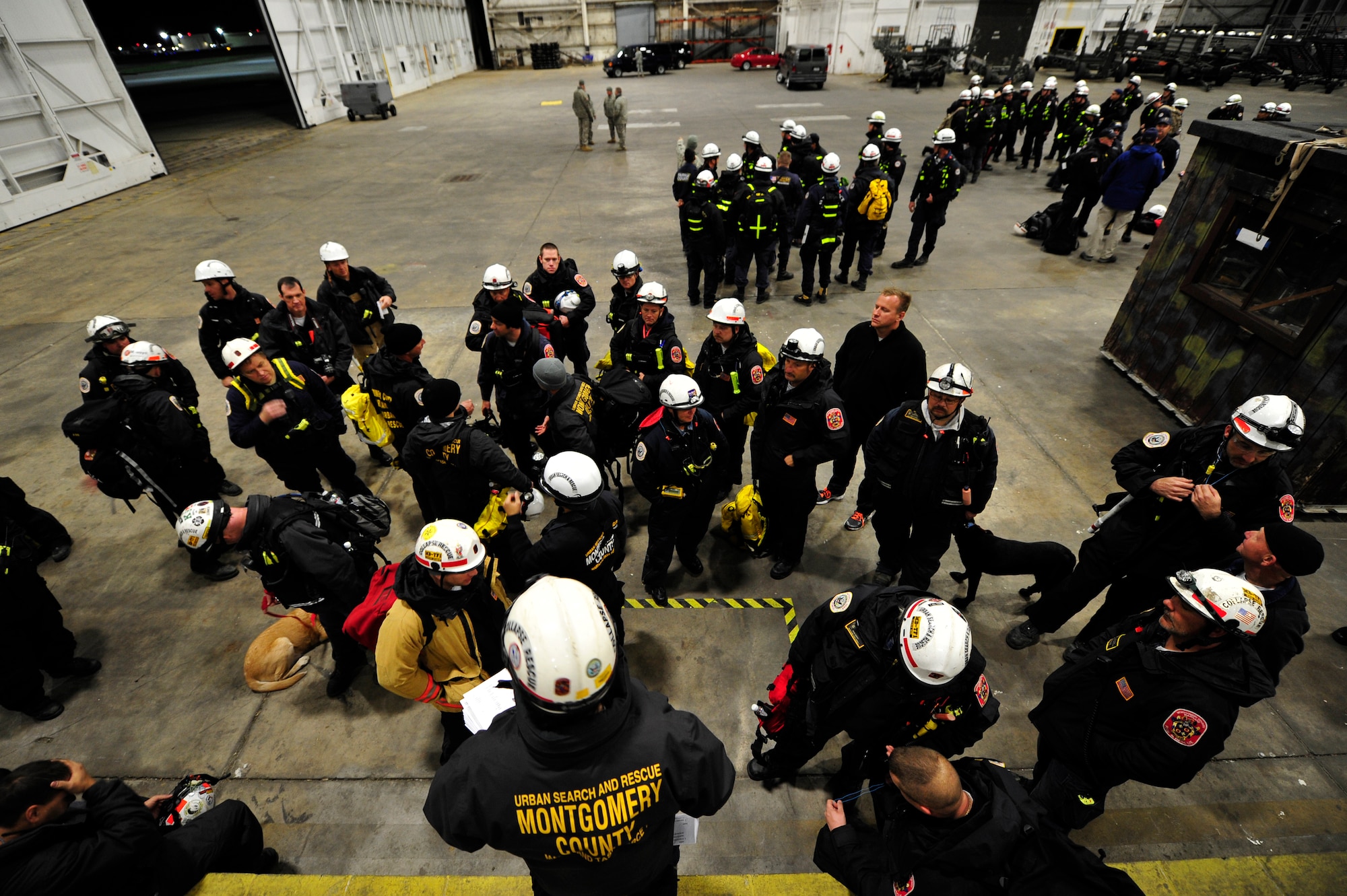 Members of the National Urban Search and Rescue Task Force receive a briefing before flying from Joint Base McGuire-Dix-Lakehurst, N.J. to Staten Island, N.Y. to conduct house-to-house searches, Nov 3, 2012. The Task Force includes state search and rescue task forces from Maryland, Virginia, and Texas. (U.S. Air Force photo by Tech. Sgt. Parker Gyokeres/Released)