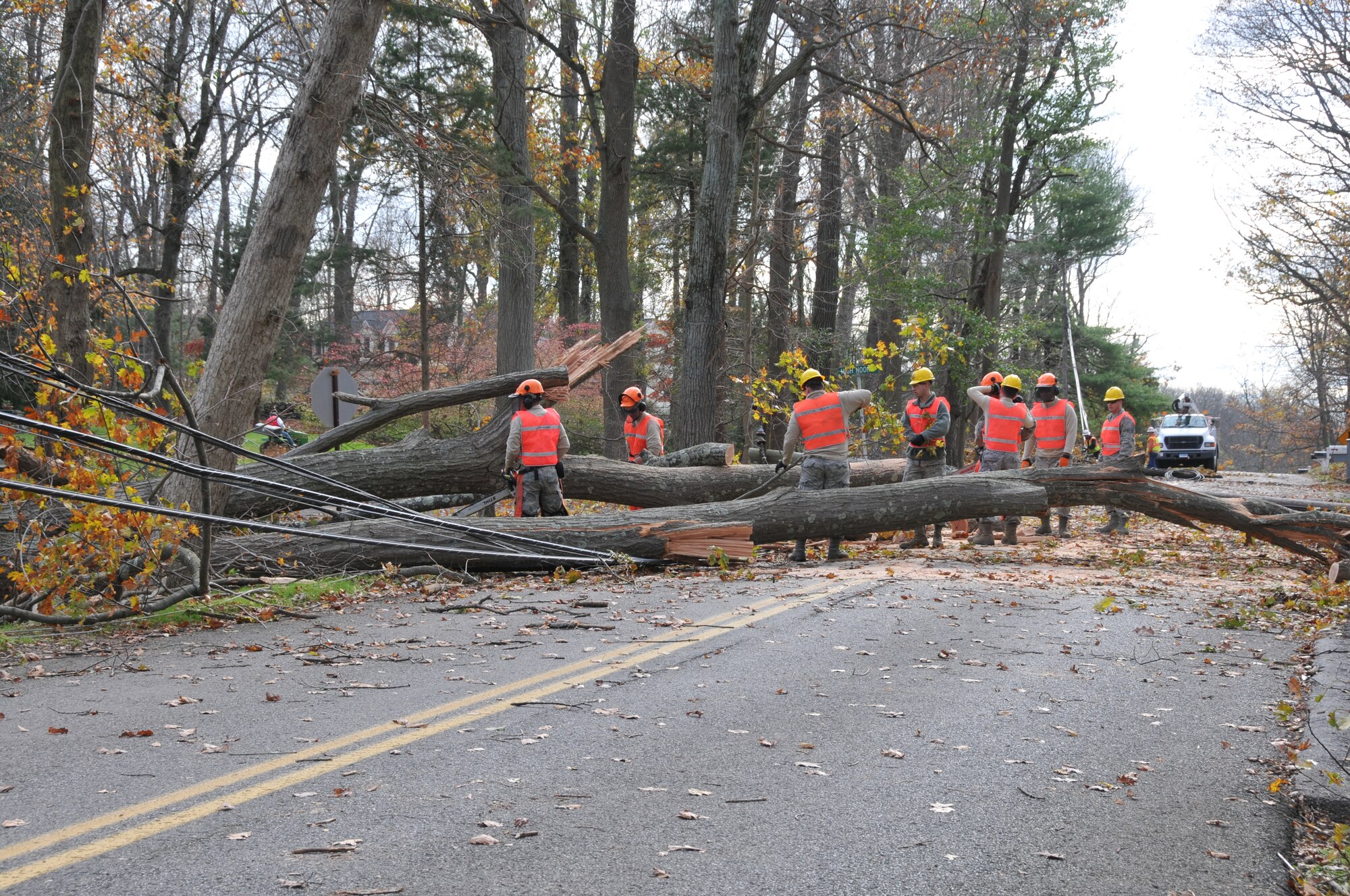 Members of the 103rd Civil Engineer Squadron chainsaw team cut up a fallen tree to help clear the road and facilitate power restoration in a Southern Connecticut town Nov. 1, 2012.The Airmen are part of the Connecticut National Guard’s emergency response in the wake of the massive destruction caused by Super Storm Sandy. (U.S. Air Force photo by Master Sgt. Erin McNamara)