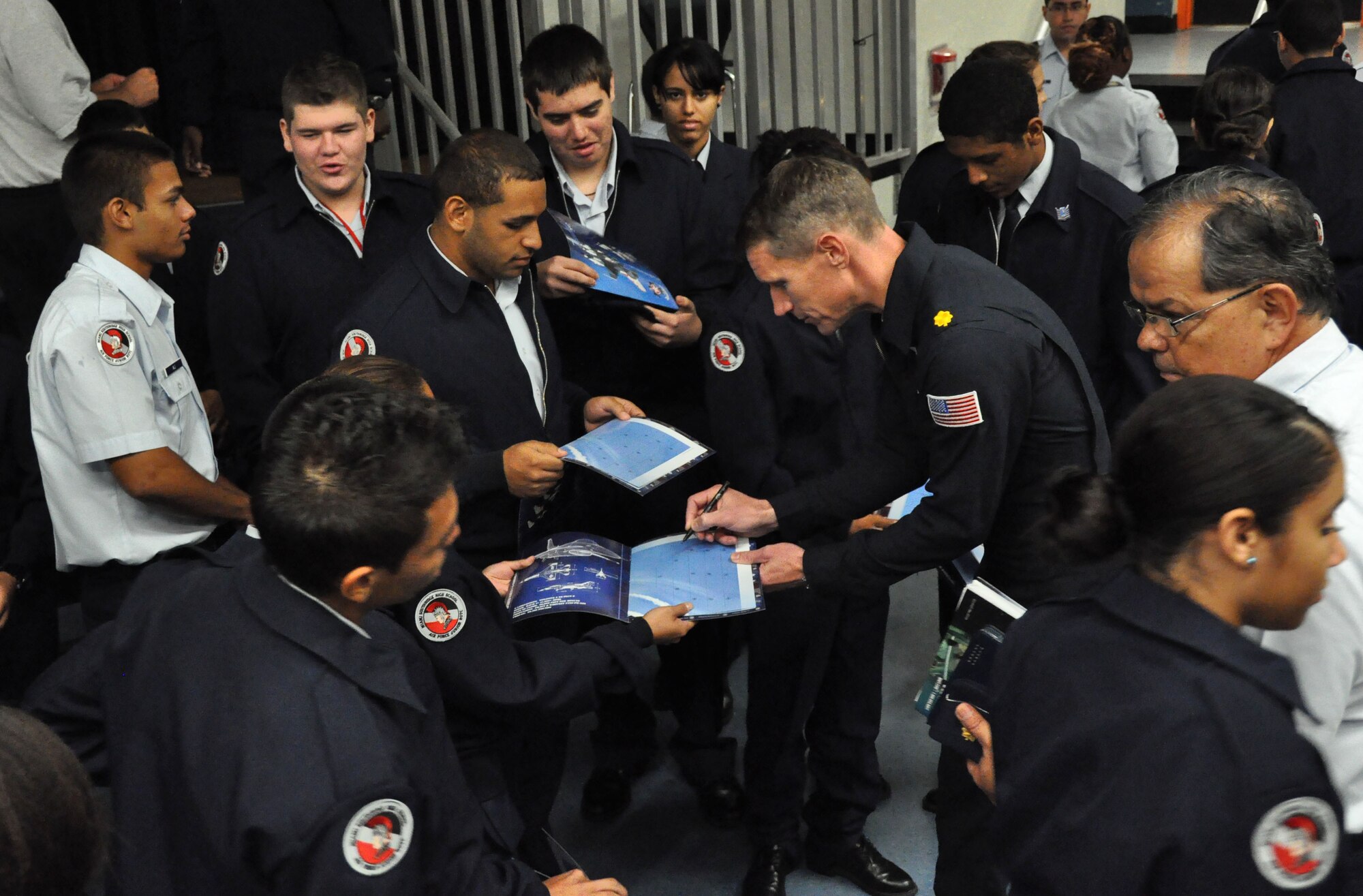 Maj. Blaine Jones, U.S. Air Force Thunderbird pilot, signs autographs for Air Force Junior ROTC students at Homestead Senior High School, Nov. 2. Members of the Thunderbirds have visited several locations throughout South Florida during their time here prior to the Wings Over Homestead air show, Nov. 3 and 4. (U.S. Air Force photo/Ross Tweten)