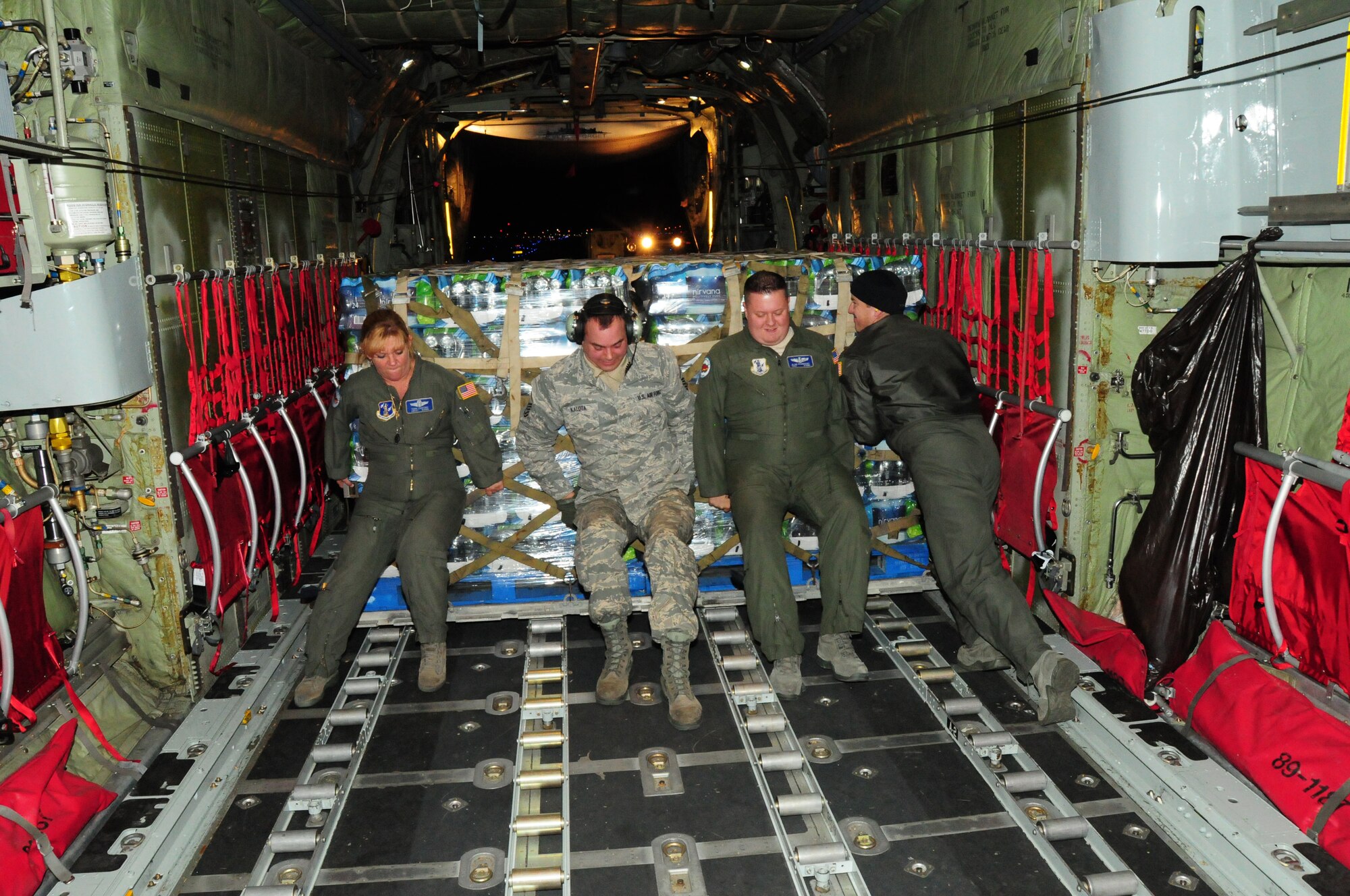 107th Airmen Senior Master Sgt. Terri Santoro, Master Sgt. Vincent Kalota, Tech Sgt. Alan Frankosky and Senior Airman Shaun Pierce use muscle power to push the pallet loaded with water off the aircraft. Nov. 2, 2012 (National Guard Photo/Senior Master Sgt. Ray Lloyd)

