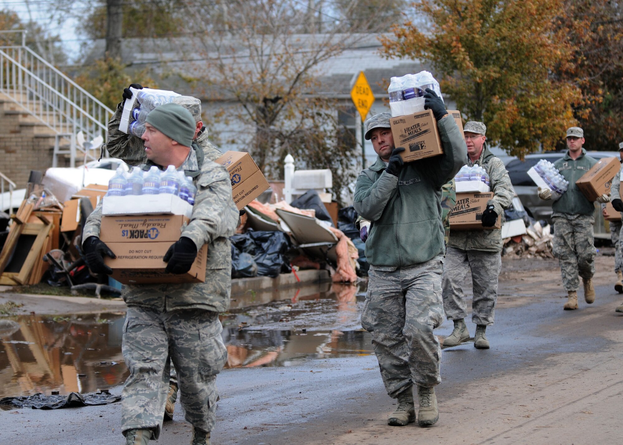 NY Air National Guard Master Sgt. Thomas Moade from the Hancock Field Air National Guard Base, Syracuse, NY leads other members of the 174th as well as members of the New York Army Guard from Newburg in taking water and cases of food to local residents in Staten Island on 2 November 2012. The food and water were provided to people who needed assistance after Hurricane Sandy took down power lines and caused massive destruction to many homes in the area leaving families desperate for help. Moade and the others were taking the food to those who could not make it to the Emergency Response location. (NYANG photo by Tech. Sgt. Jeremy M. Call/Released)