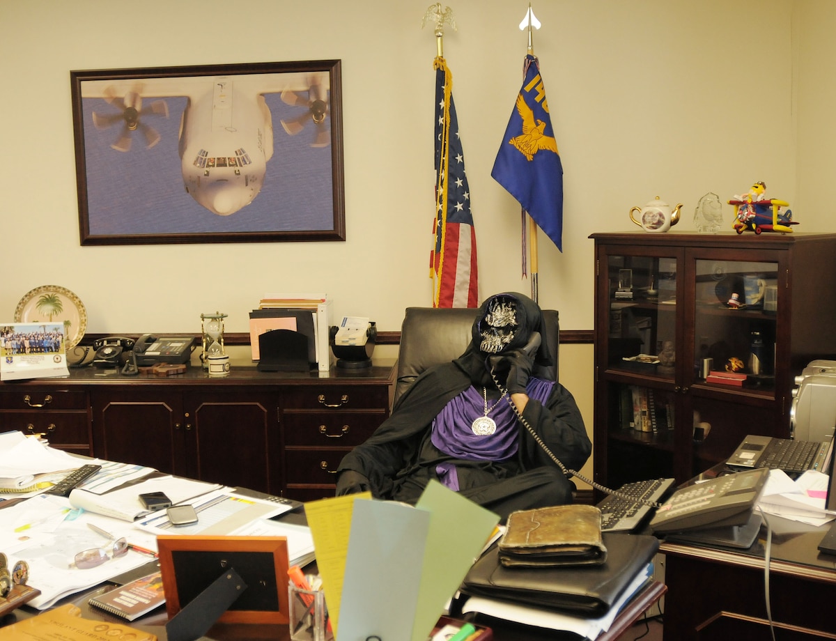 The wing commander, Col. Paul Hargrove (aka Emperor of Evil), is hard atwork before the annual Halloween boo-be-que. (photo by: Master Sgt. DavidButtner)