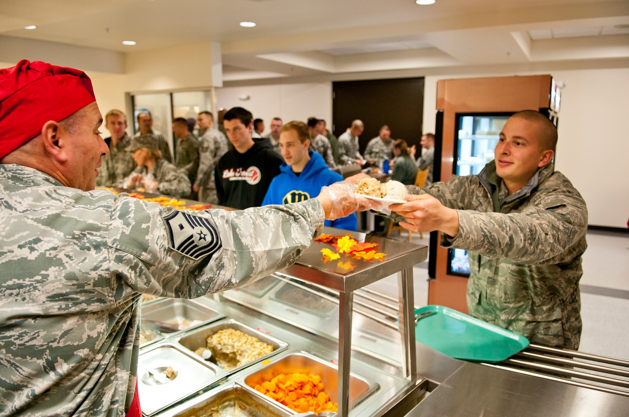 Master Sgt. Michael Harvey, left, first sergeant for the 115th Security Forces squadron, serves Senior Airman Donovan Halajian, crew chief for the 115th Maintenance Group, his holiday meal during the November Unit Training Assembly, at Truax Field, Madison, Wis., Nov. 3, 2012. (U.S. Air Force photo by Tech. Sgt. Ashley Bell)