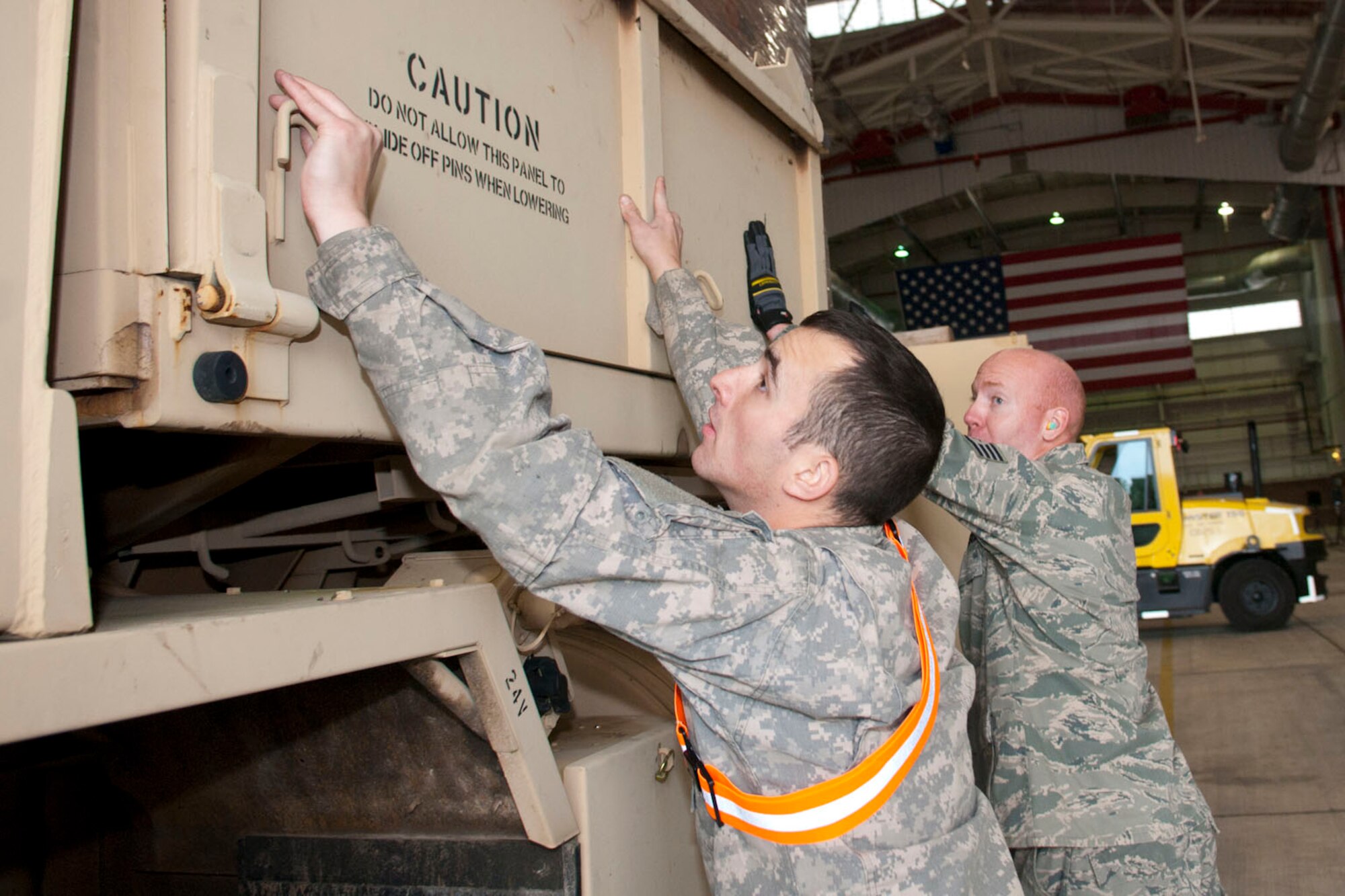 West Virginia National Guardsmen, Spc. Craig Brown, with the 77th Brigade’s 201st Forward Support Company and Staff Sgt. John Wishmyer, 167th Airlift Wing, pin down the sides of a truck full of boxed ready-to-eat meals in a hangar at the 167th Airlift Wing, Martinsburg, W.Va., Nov.2, 2012. The truck was destined for Tucker County, W.Va., one of the W.Va. counties with heavy snow and power outages. The 167th AW is serving as a staging area for disaster relief supplies which will then be transported throughout West Virginia as needed. The West Virginia National Guard has over 200 members aiding in recovery efforts from Hurricane Sandy.  The storm blanketed the state with heavy snow and rains and also had severe winds that left homes and properties damaged.  Guardsmen are involved in numerous aspects of the operations from search and rescue missions to debris removal. (Air National Guard photo by Master Sgt. Emily Beightol-Deyerle)