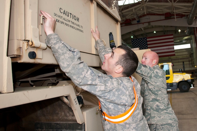 West Virginia National Guardsmen, Spc. Craig Brown, with the 77th Brigade’s 201st Forward Support Company and Staff Sgt. John Wishmyer, 167th Airlift Wing, pin down the sides of a truck full of boxed ready-to-eat meals in a hangar at the 167th Airlift Wing, Martinsburg, W.Va., Nov.2, 2012. The truck was destined for Tucker County, W.Va., one of the W.Va. counties with heavy snow and power outages. The 167th AW is serving as a staging area for disaster relief supplies which will then be transported throughout West Virginia as needed. The West Virginia National Guard has over 200 members aiding in recovery efforts from Hurricane Sandy.  The storm blanketed the state with heavy snow and rains and also had severe winds that left homes and properties damaged.  Guardsmen are involved in numerous aspects of the operations from search and rescue missions to debris removal. (Air National Guard photo by Master Sgt. Emily Beightol-Deyerle)