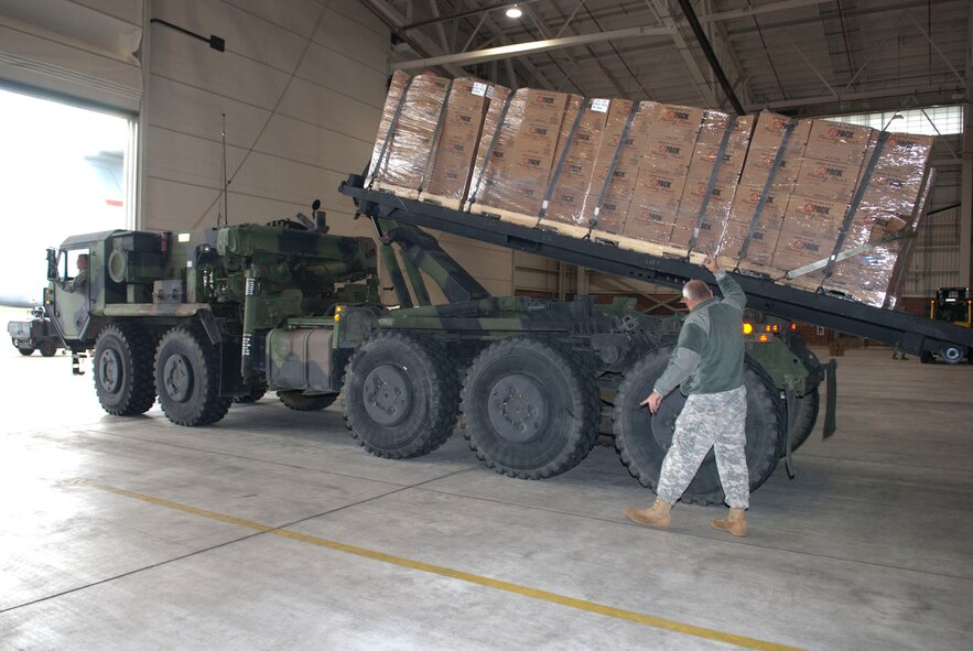 West Virginia National Guardsman, Staff Sgt. Randolph Cutlip, assigned to the 77th Brigade’s  201st  Forward Support Company, directs a roll-off with pallets of boxed ready-to-eat meals into place in a aircraft hangar at the 167th Airlift Wing, Martinsburg, W.Va., Nov.2, 2012. The 167th AW is serving as a staging area for disaster relief supplies which will then be transported throughout West Virginia as needed. The West Virginia National Guard has over 200 members aiding in recovery efforts from Hurricane Sandy.  The storm blanketed the state with heavy snow and rains and also had severe winds that left homes and properties damaged.  Guardsmen are involved in numerous aspects of the operations from search and rescue missions to debris removal. (Air National Guard photo by Master Sgt. Emily Beightol-Deyerle)