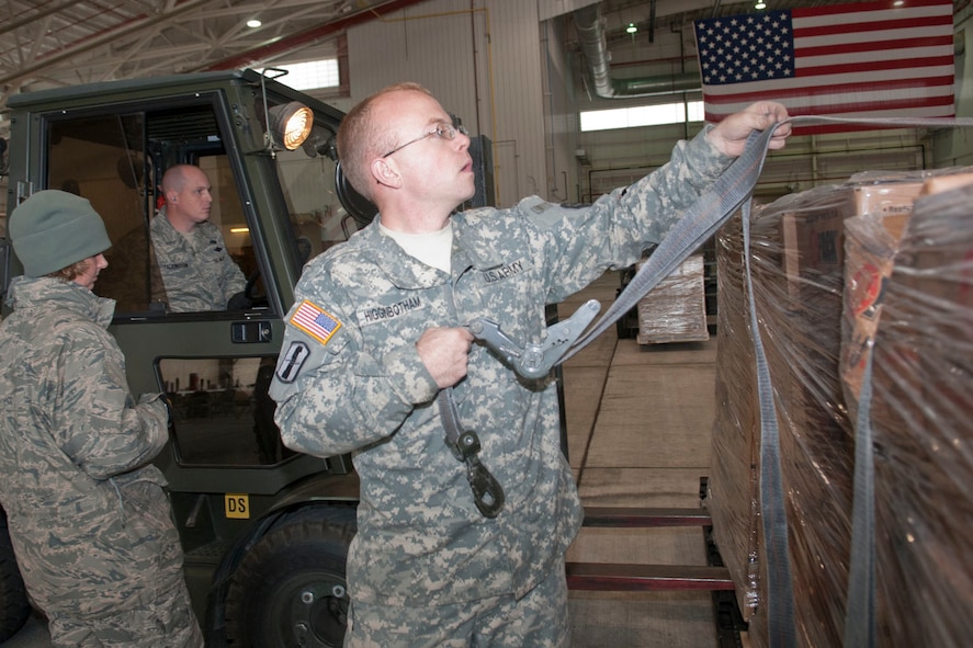 West Virginia National Guardsman, Spc. Josh Higginbotham, assigned to the 77th Brigade’s 201st Forward Support Company, ties down a pallet as another pallet is being placed onto the roll-off inside a hangar at the 167th Airlift Wing, Martinsburg, W.Va., Nov.2, 2012. The 167th AW is serving as a staging area for disaster relief supplies which will then be transported throughout West Virginia as needed. The West Virginia National Guard has over 200 members aiding in recovery efforts from Hurricane Sandy.  The storm blanketed the state with heavy snow and rains and also had severe winds that left homes and properties damaged.  Guardsmen are involved in numerous aspects of the operations from search and rescue missions to debris removal. (Air National Guard photo by Master Sgt. Emily Beightol-Deyerle)