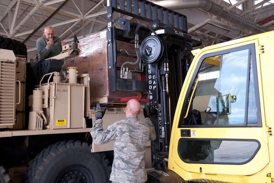 West Virginia National Guardsmen, Staff Sgt. Randolph Cutlip, a truck driver with the 77th Brigade’s  201st  Forward Support Company and Staff Sgt. John Wishmyer, 167th Airlift Wing, direct a pallet of ready to eat boxed meals onto a truck at the 167th AW, based in Martinsburg, W.Va., Nov. 2, 2012. The 167th AW is serving as a staging area for disaster relief supplies which will then be transported throughout West Virginia as needed. The West Virginia National Guard has over 200 members aiding in recovery efforts from Hurricane Sandy.  The storm blanketed the state with heavy snow and rains and also had severe winds that left homes and properties damaged.  Guardsmen are involved in numerous aspects of the operations from search and rescue missions to debris removal. (Air National Guard photo by Master Sgt. Emily Beightol-Deyerle)