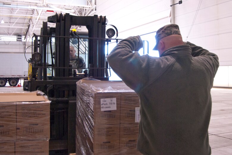 Staff Sgt. Joshua Wishmyer signals to his brother Staff Sgt. John Wishmyer as he moves a pallet of boxed meals at the 167th Airlift Wing, West Virginia Air National Guard, based in Martinsburg W.Va., Thursday Nov. 1, 2012. The 167th AW is serving as a staging area for disaster relief supplies which will then be transported throughout West Virginia as needed. The West Virginia National Guard has over 200 members aiding in recovery efforts from Hurricane Sandy.  The storm blanketed the state with heavy snow and rains and also had severe winds that left homes and properties damaged.  Guardsmen are involved in numerous aspects of the operations from search and rescue missions to debris removal. (Air National Guard photo by Master Sgt. Emily Beightol-Deyerle)