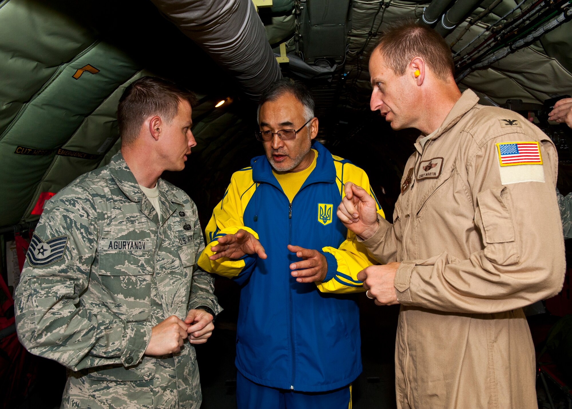 Left, Tech. Sgt. Sergey Aguryanov translates as Tursunbay Bakir Uulu and Col. Corey Martin discuss how the boom litter operates on the back of a KC-135 Stratotanker during an air refueling demonstration over Kyrgyzstan, Nov. 2, 2012. Members of the Kyrgyz Republic Parliament toured the Transit Center at Manas and experienced an air refueling capabilities demonstration. Martin is the Transit Center director, Aguryanov is a Transit Center Theatre Security Cooperation host nation liaison deployed from the U.S. Air Force Academy, Colo., and Uulu is a member of Kyrgyz Republic Parliament. (U.S. Air Force photo/Senior Airman Brett Clashman)