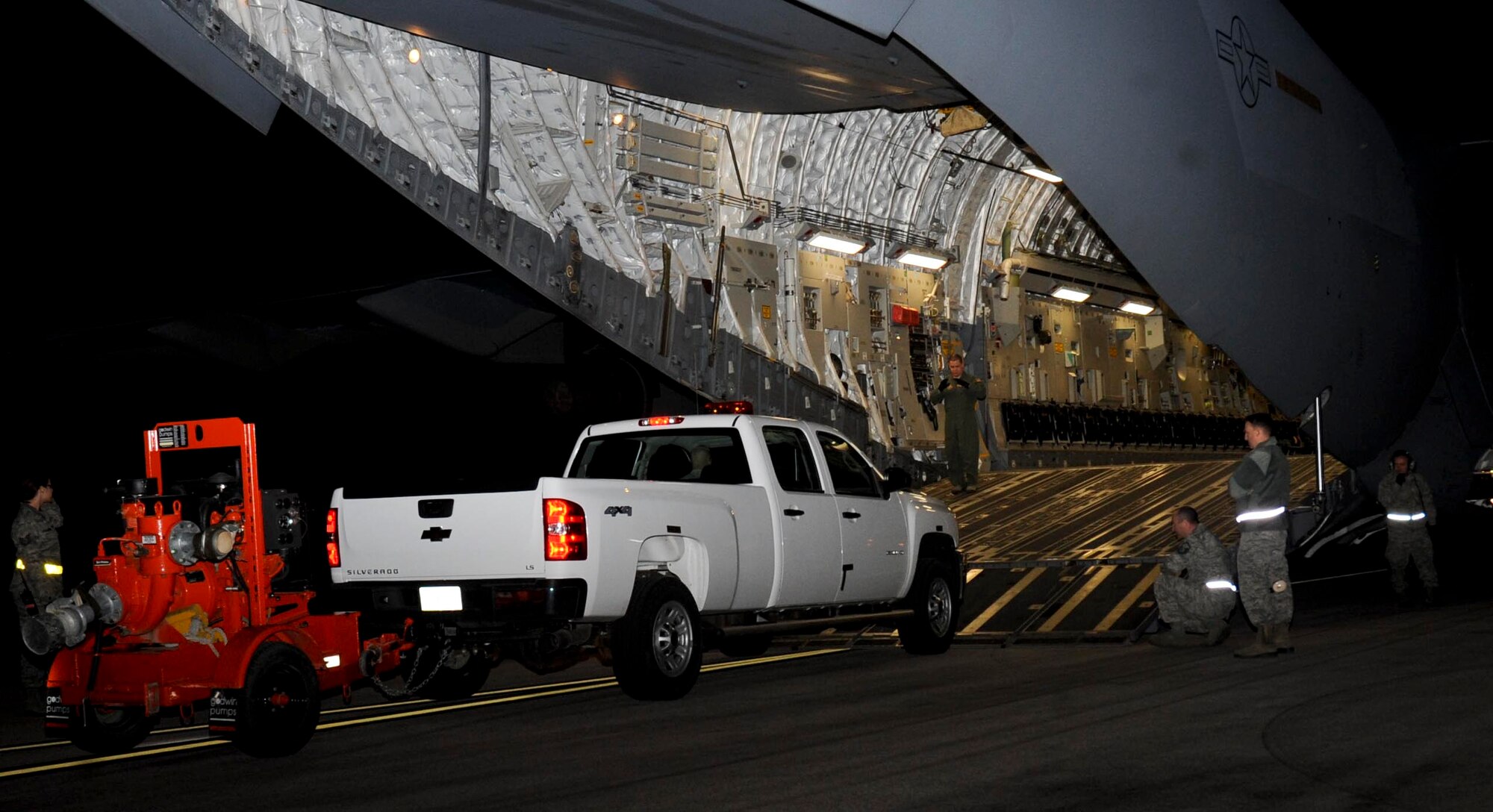 Airmen from the 28th Logistics Readiness Squadron help load a four-wheel drive truck with a water pump onto a C-17 Globemaster at Ellsworth Air Force Base, S.D., Nov. 2, 2012. Along with equipment and supplies, eight Airmen from the 28th Civil Engineer Squadron are being sent to McGuire Air Force Base, N.J., in response to a tasking from U.S. Air Force North to support Hurricane Sandy relief efforts. (U.S. Air Force photo by Airman 1st Class Anania Tekurio/Released)