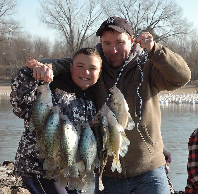 Fishing father and son with string of crappies