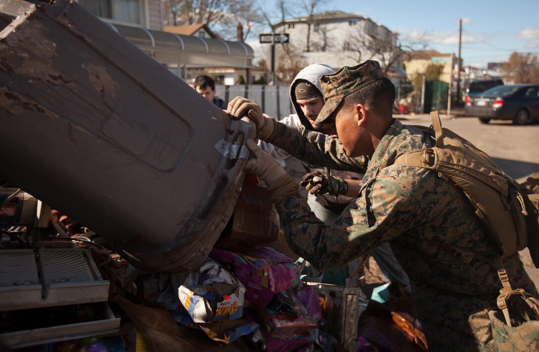 Lance Cpl. Matthew Reynoso, an automotive organizational mechanic. with the 26th Marine Expedionary Unit and a native of Bronx, N.Y., helps take out trash on Staten Island, N.Y., Nov. 4. The 26th MEU is able to provide generators, fuel, clean water, and helicopter lift capabilities to aid in disaster relief efforts. The 26th MEU is currently conducting pre-deployment training, preparing for their departure in 2013. As an expeditionary crisis response force operating from the sea, the MEU is a Marine Air-Ground Task Force capable of conducting amphibious operations, crisis response, and limited contingency operations.