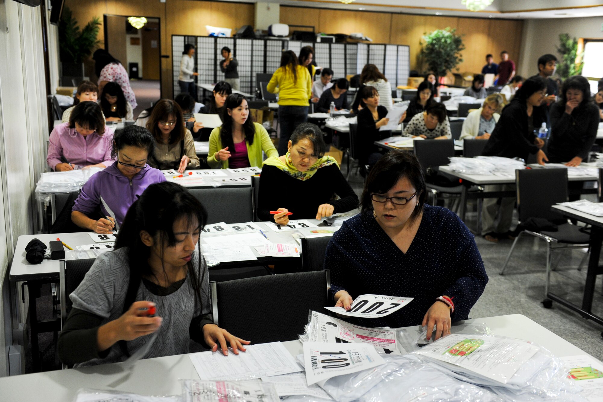 Local volunteers make t-shirt packages at the Schilling Community Center for the Kadena Special Olympics' athletes to help prepare for the KSO on Kadena Air Base, Japan, Nov. 2, 2012. More than 1,300 t-shirts packages are were made for the athletes; each package includes a t-shirt, number tag and a description of events of the KSO. (U.S. Air Force photo/Airman 1st Class Justin Veazie)