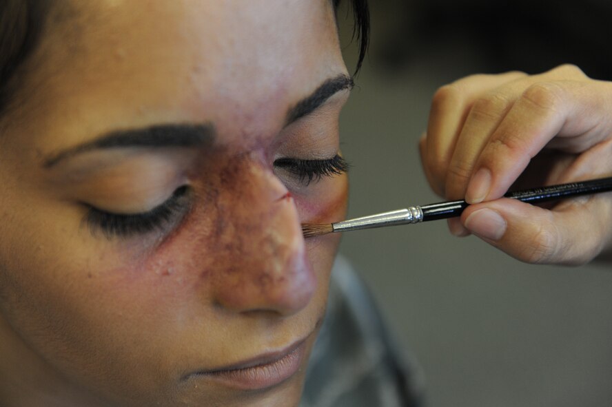 U.S. Air Force Staff Sgt. Kyla McKnight, 18th Contracting Squadron contracting administrator, has make-up applied to resemble a broken nose for the Domestic Violence Awareness campaign on Kadena Air Base, Japan, Oct. 9, 2012. McKnight kept the faux wound on all day as she did her daily routine in support of the "Thanks for asking" campaign. The two goals for the campaign are to enhance awareness of the available services for domestic violence and encourage people to speak up. (U.S. Air Force photo/Airman 1st Class Malia Jenkins) 
