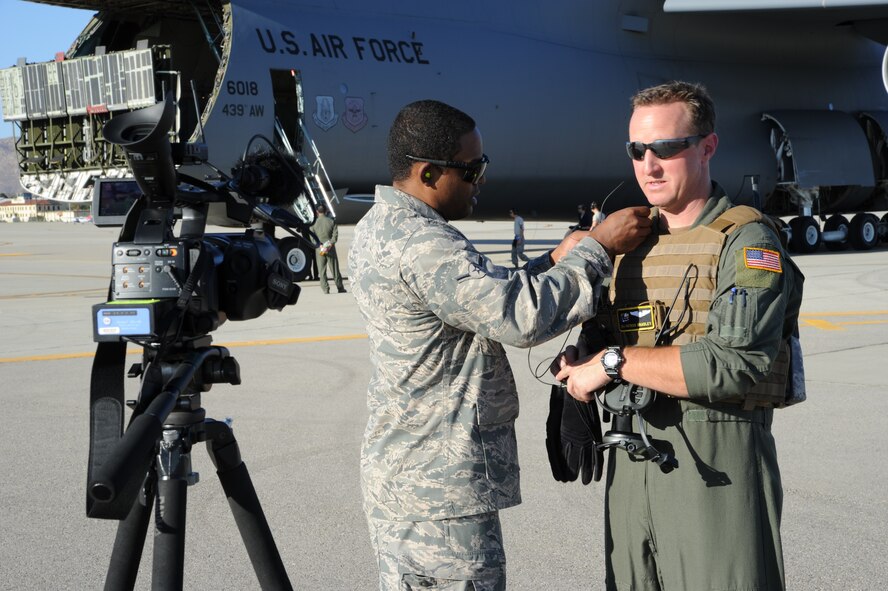 U.S. Air Force Airmen Quiche Jackson, 4th Combat Camera Squadron, prepares Senior Airman Patrick Bradley, 452 Airlift Control Flight for an interview on the flightline at March Air Reserve Base, Calif., Nov. 04, 2012. The Department of Defense continues to flow forces, capabilities and logistical  supplies to the New York/ New Jersey region in support of the Federal Management Agency's response to Hurricane Sandy from March Air Reserve Base, Calif.