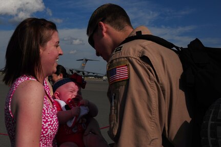Whitney Hooper holds five-month-old daughter Grace Hooper while welcoming home Capt. Randall Hooper, 17th Airlift Squadron pilot Nov. 4, 2012, at Joint Base Charleston - Air Base, S.C. While deployed, the 17th AS supported roughly 2,467 sorties, logged more than 5,600 combat flying hours and airlifted more than 105 million pounds of cargo and more than 14,000 personnel throughout Southwest Asia.(U.S. Air Force photo/ Airman 1st Class Chacarra Walker)