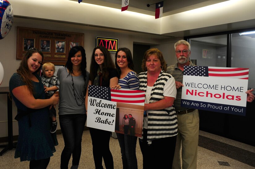 Family and friends hold signs while waiting for the return of the 17th Airlift Squadron Nov. 4, 2012, at Joint Base Charleston - Air Base, S.C. While deployed, Airmen of the 17th AS served under the 816th Expeditionary Airlift Squadron and were responsible for airlift, airdrop and aeromedical evacuations, all of which directly support the combatant commander. (U.S. Air Force photo/ Airman 1st Class Chacarra Walker)