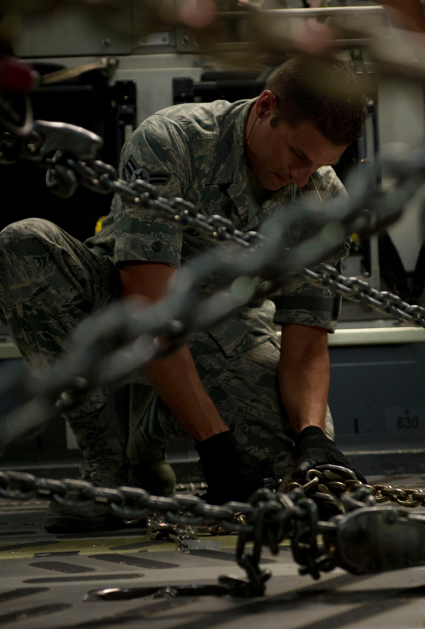 An Airman from the 621st Contingency Response Wing, Travis Air Force Base, Calif. tightens a chain while helping Airmen from the Arizona Air National Guard to secure a vehicle in an Air Force C-17 Globemaster III at the Sky Harbor Air National Guard Base in Phoenix, Ariz., bound for N.Y. to support the Hurricane Sandy relief efforts, November 3, 2012. The 621st CRW is highly-specialized in training and rapidly deploying personnel to quickly open airfields and establish, expand, sustain, and coordinate air mobility operations. (U.S. Air Force photo by Staff Sgt. Gustavo Gonzalez)