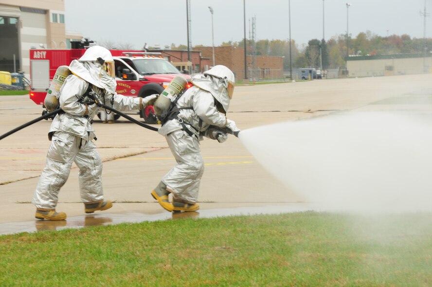 180th Fighter Wing firefighters approach an F-16 during an exercise to extract an unresponsive pilot on the flight line of the 180FW, Ohio, Oct. 14, 2012.  180FW firefighters were performing the exercise as part of the Consolidated Unit Inspection.  (U.S. Air Force photo by Senior Airman Amber Williams/Released)