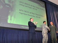 Air Force Reservists Senior Master Sgt. Jeff Flight (far right) shakes hands with Tech. Sgt. Rene Hernandez as Col. Jay Pittman, 302nd Airlift Wing commander, congratulates them both Nov. 4 at Peterson Air Force Base, Colo. Hernandez and Flight were awarded fthe Colorado chapter of the Air Force Association during a wing commander's call. Flight, assigned to the 302nd Operations Group, was recognized as the Colorado AFA Senior Non-commissioned Officer of the Year, while Hernandez won the same award in the Non-commissioned Officer category. (U.S. Air Force photo/Staff Sgt. Stephen J. Collier)