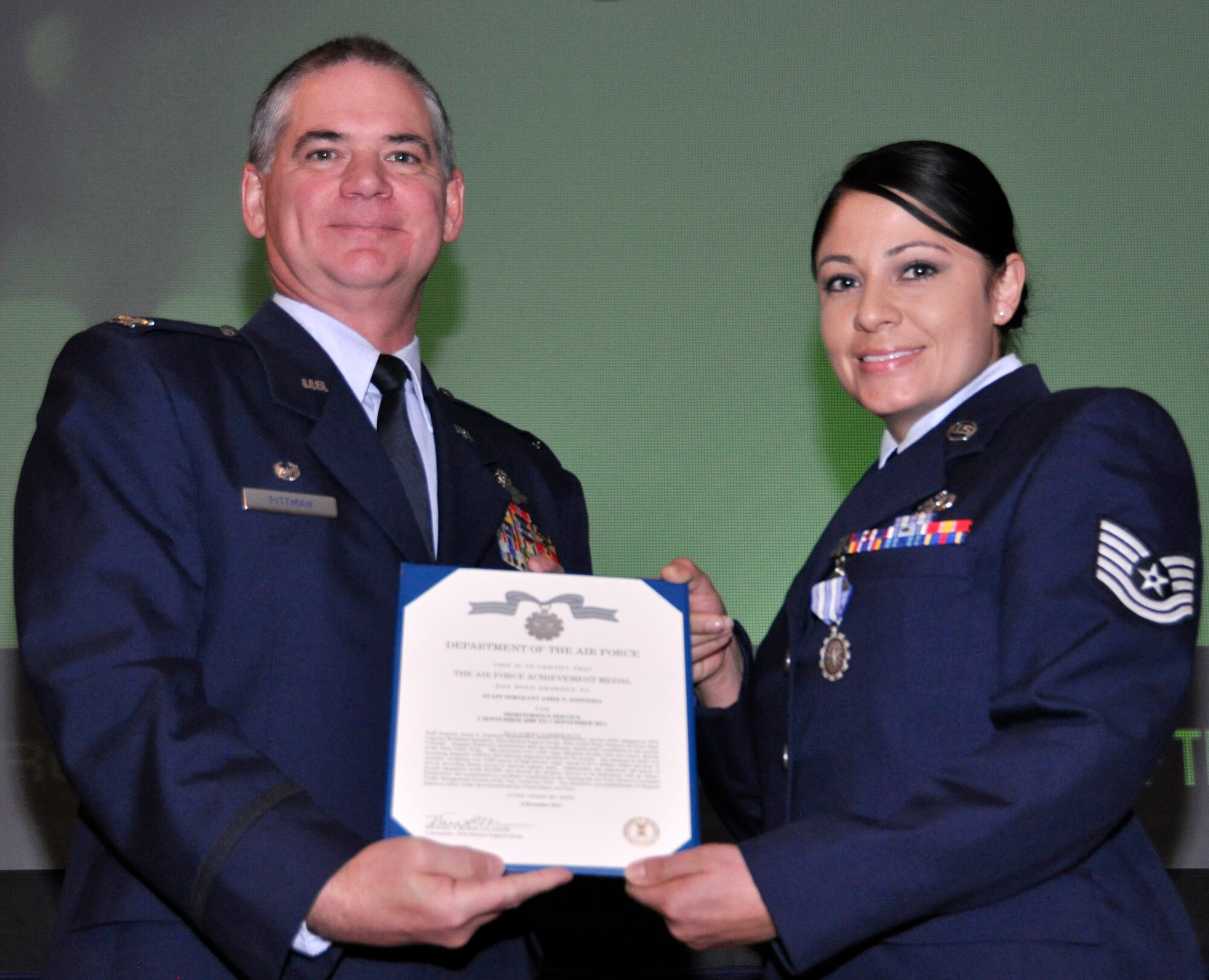 Air Force Reserve Col. Jay Pittman, 302nd Airlift Wing commander, presents the Air Force Achievement Medal to Staff Sgt. Amee Espinoza Nov. 4 during a wing commander's call at Peterson Air Force Base, Colo. Espinoza, assigned to the 302nd Logistics Readiness Squadron, earned the medal for several actions performed in the area of logistical coordination, including her processing of more than 3,000 cargo shipment records with zero errors. (U.S. Air Force photo/Staff Sgt. Stephen J. Collier)