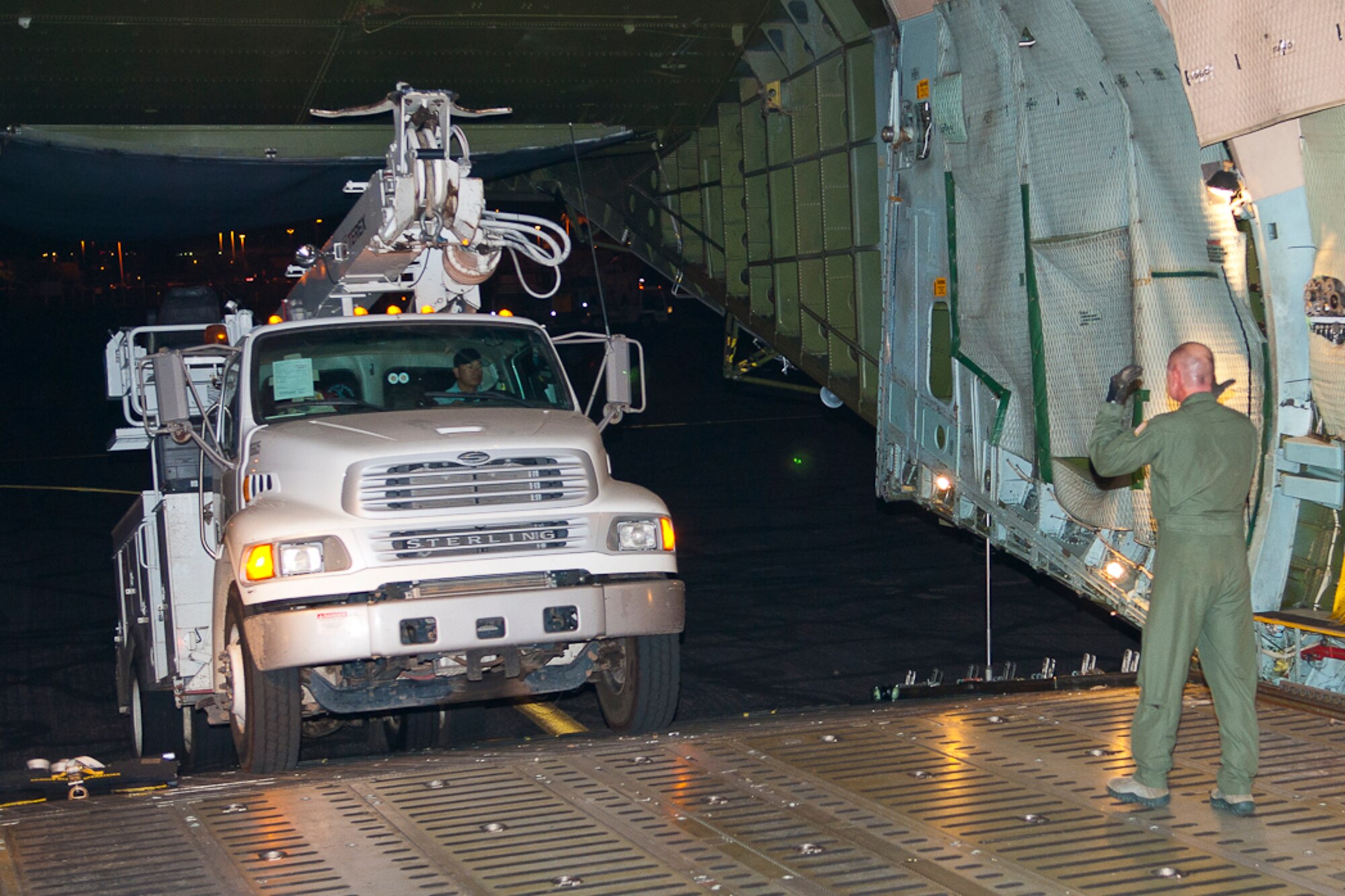 Senior Master Sgt. Doug Ferrell directs a power truck onto a C-5 Galaxy aircraft at Phoenix Sky Harbor International Airport Nov. 2, 2012. The 167th Airlift Wing transported four power trucks and utility workers to Stewart Air National Guard Base, New York. (Air National Guard photo by 2nd Lt. Stacy Gault)