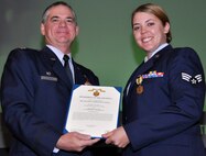 Air Force Reserve Col. Jay Pittman, 302nd Airlift Wing commander, presents the Air Force Accommodation Medal to Senior Airman Suzanne Geidel Nov. 4 during a wing commander's call at Peterson Air Force Base, Colo. Geidel, assigned to the 302nd Aeromedical Staging Squadron, earned the medal for actions in support of military members deploying overseas, backfilling for a critical Air Reserve Technician vacancy and strengthening Peterson's Total Force relationship with membership in the Occupational and Environmental Health Working Group. (U.S. Air Force photo/Staff Sgt. Stephen J. Collier)