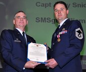 Air Force Reserve Col. Jay Pittman, 302nd Airlift Wing commander, presents the Air Force Meritorious Service Medal to Senior Master Sgt. William Ahrens Nov. 4 during a wing commander's call at Peterson Air Force Base, Colo. Ahrens, assigned to the 302nd Maintenance Squadron, earned the medal for actions performed while supporting the wing's C-130 flying mission. (U.S. Air Force photo/Staff Sgt. Stephen J. Collier)