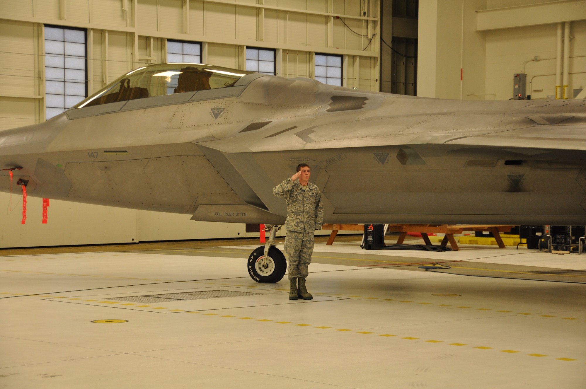 Senior Airman Robert Kerr, assistant dedicated crew chief assigned to the 477th Aircraft Maintenance Squadron, unveils Col. Tyler Otten's name on aircraft 0147. Aircraft 0147 is an F-22 assigned to the 3rd Wing and has been recently named as the 477th FG flag ship. Otten took command from Col. Bryan Radliff during a ceremony here Nov. 2. (U.S. Air Force Reserve/Tech. Sgt. Dana Rosso)
