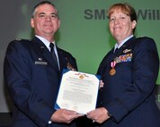Air Force Reserve Col. Jay Pittman, 302nd Airlift Wing commander, presents the Air Force Meritorious Service Medal to Lt. Col. Lieselotte Kennedy Nov. 4 during a wing commander's call at Peterson Air Force Base, Colo. Kennedy, assigned to the 34th Aeromedical Evacuation Squadron, earned the medal for actions performed while deployed to Afghanistan. (U.S. Air Force photo/Staff Sgt. Stephen J. Collier)