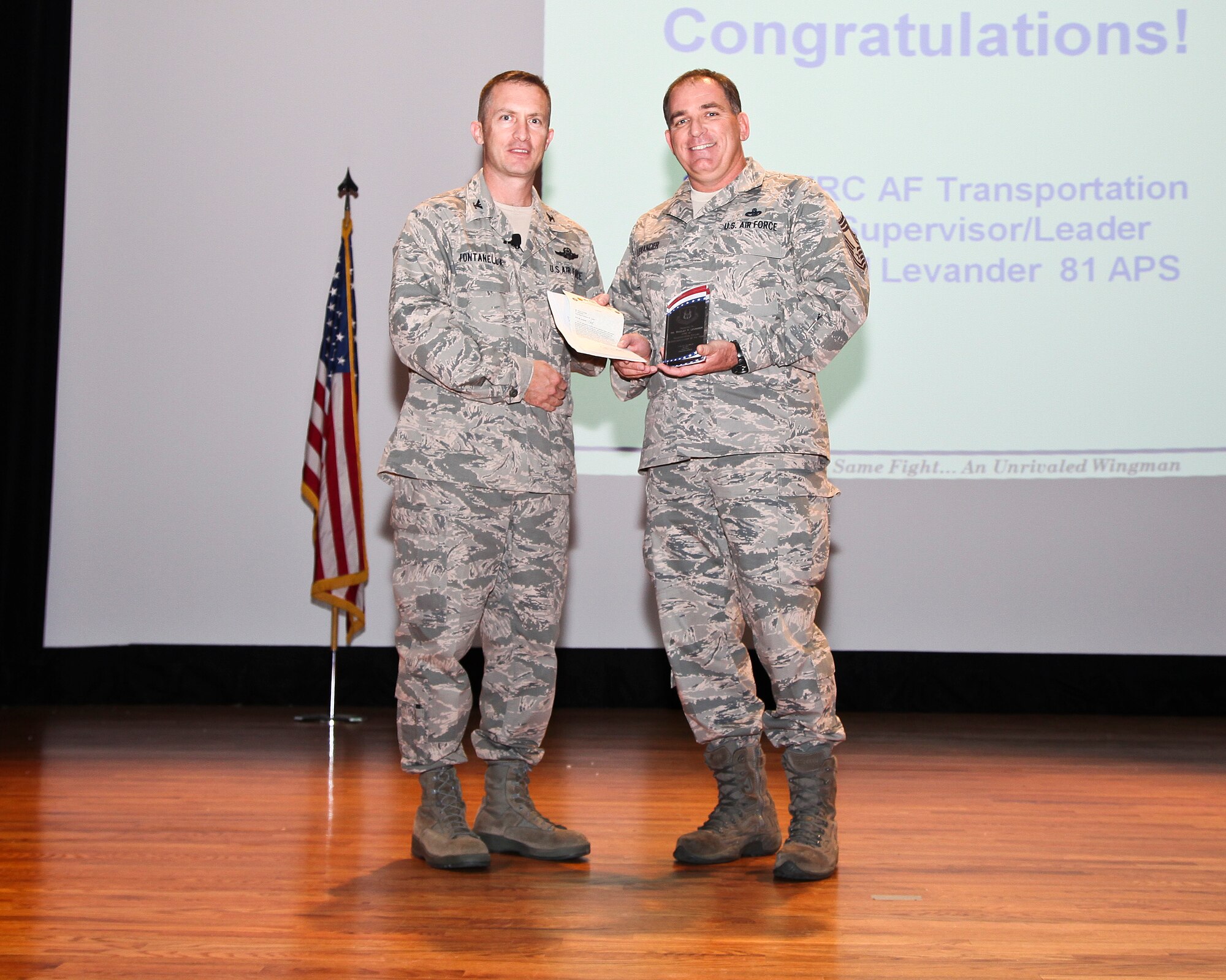 81st Aerial Port Squadron air transportation manager Chief Master Sgt. Bradley Levander receives an award from 315th Airlift Wing commander Col. James Fontanella during commanders call Nov. 3, 2012 at the base theatre here on Joint Base Charleston, S.C. Levander was awarded for being the 2011 Air Force Reserve Command Air Force transportation civilian supervisor and leader of the year. (U.S. Air Force photo by Staff Sgt. Rashard Coaxum)