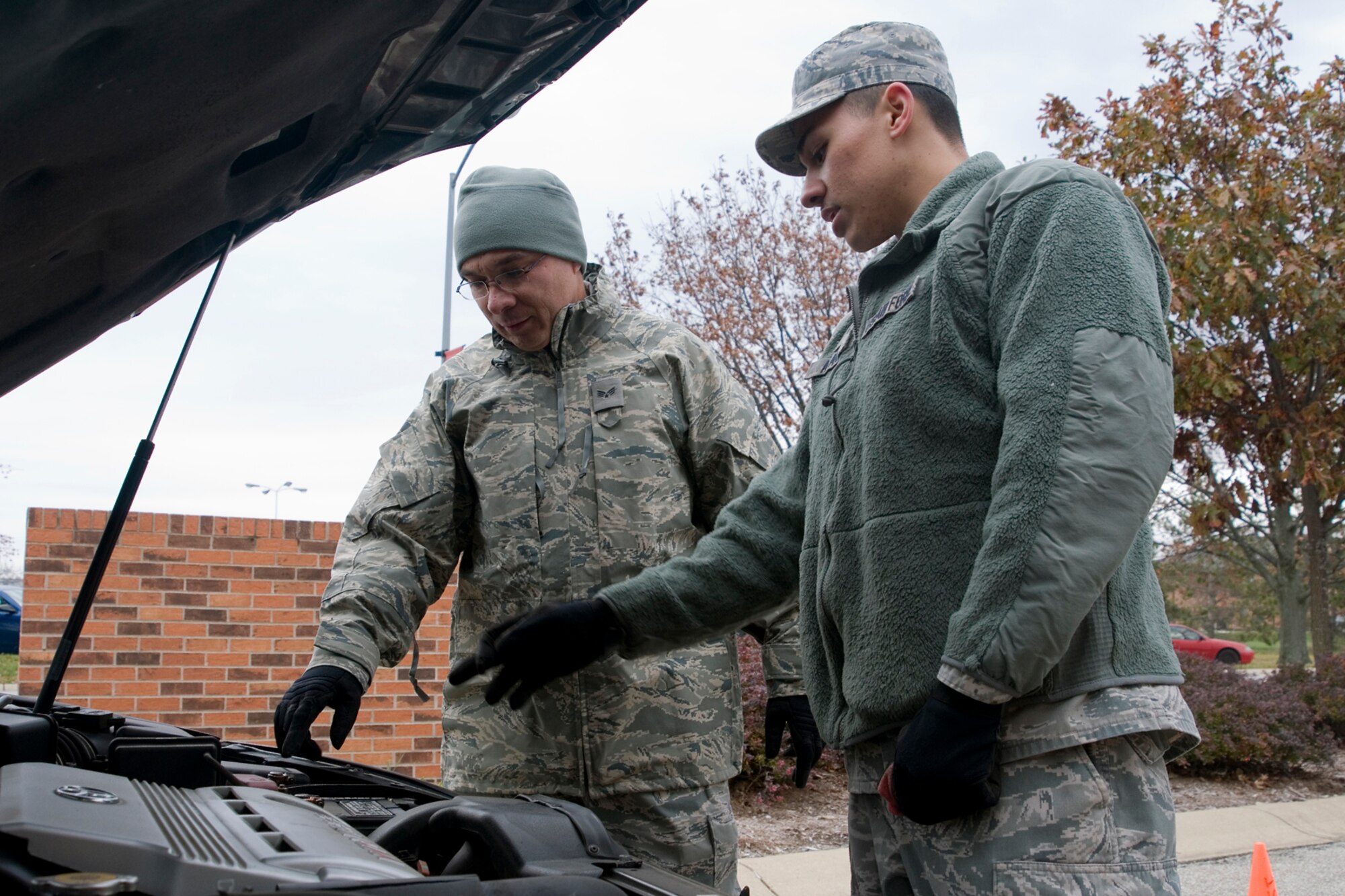 GRISSOM AIR RESERVE BASE, Ind. -- Senior Airmen Kenneth Ray and Elias Alanis, 434th Civil Engineer Squadron electrical systems journeymen, check the oil and other fluids under the hood of an Airman's vehicle here Nov. 3. The 434th CES conducted vehicle safety checks ahead of the winter season. (U.S. Air Force photo/Senior Airman Andrew McLaughlin) 