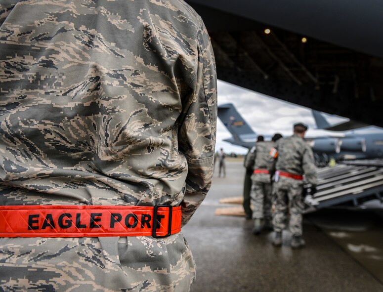 62nd Aerial Port Squadron "Port Dawgs" prepare the ramp of a C-17 Globemaster III aircraft for the loading of a utility vehicle belonging to Seattle City Light, Nov. 3, 2012. The 62nd APS Airmen's unique nickname is an acronym of their mission statements of "Professional Airmen/Civilians, Outstanding performance, Ready 24/7 365, Teamwork, Delivering our nation's assets, Always prepared, Whatever it takes, and Global impact." (U.S. Air Force photo/Staff Sgt. Sean Tobin)
