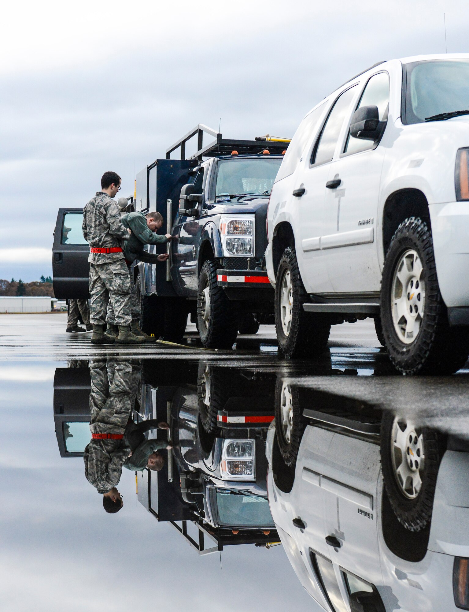 (Left) Airman 1st Class Tyler Smith and (Right) Staff Sgt. Bradley Burfield, 62nd Aerial Port Squadron joint inspectors, measure and mark the center of balance on a Bonneville Power Administration vehicle, Nov. 3, 2012, at Joint Base Lewis-McChord, Wash. The 62nd APS, whose motto is "Whatever it Takes," work day and night processing cargo of all shapes and sizes, for deployment to anywhere in the world the equipment is needed. (U.S. Air Force photo/Staff Sgt. Sean Tobin)