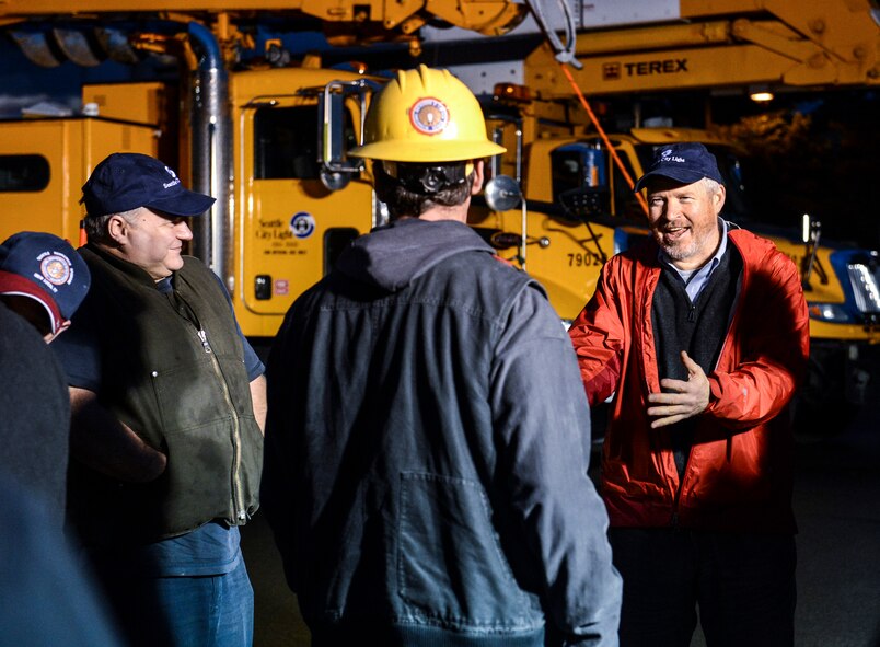 Seattle Mayor, Mike McGinn (right), jokes with Seattle City Light utility workers in the early morning, Nov. 3, 2012, prior to the workers' departure for New York's John F. Kennedy airport, at Joint Base Lewis-McChord, Wash. In response to President Obama's call for federal support of the Hurricane Sandy relief efforts, the U.S. Air Force mobilized resources from around the nation to airlift workers and equipment to the areas affected by the superstorm. (U.S. Air Force photo/Staff Sgt. Sean Tobin)