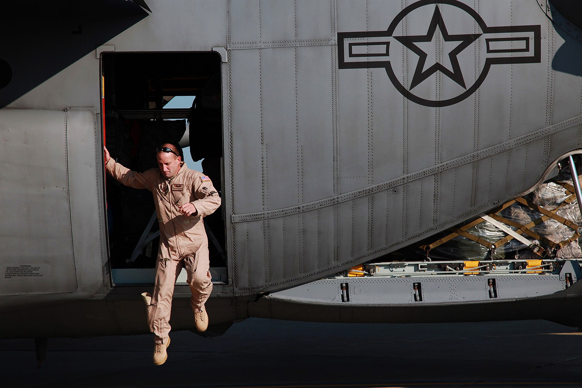 Tech. Sgt. Rich Newhouse, a 911th Airlift Wing loadmaster exits a C-130 Hercules aircraft which is parked at the Pittsburgh International Airport flightline, Sep. 06, 2012. Newhouse secured the cargo and passengers on board the aircraft and assured that everything in the cargo area remains safe during the flight before the initial take-off to an overseas location. (U.S. Air Force photo by Tech. Sgt. Ralph Van Houtem/Released)