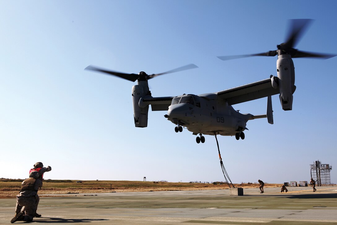 An MV-22B Osprey takes off after landing support specialists attached a 7,000-pound concrete block during dual-point external training on Ie Shima Oct. 25. Marine Medium Tiltrotor Squadron 265 recently switched from the CH-46E Sea Knight helicopter to the Osprey, which allows for dual-point external operations at faster speeds. The landing support specialists are with Combat Logistics Regiment 37, 3rd Marine Logistics Group, III Marine Expeditionary Force. The pilot and crew are with VMM-265, 1st Marine Aircraft Wing, III MEF.