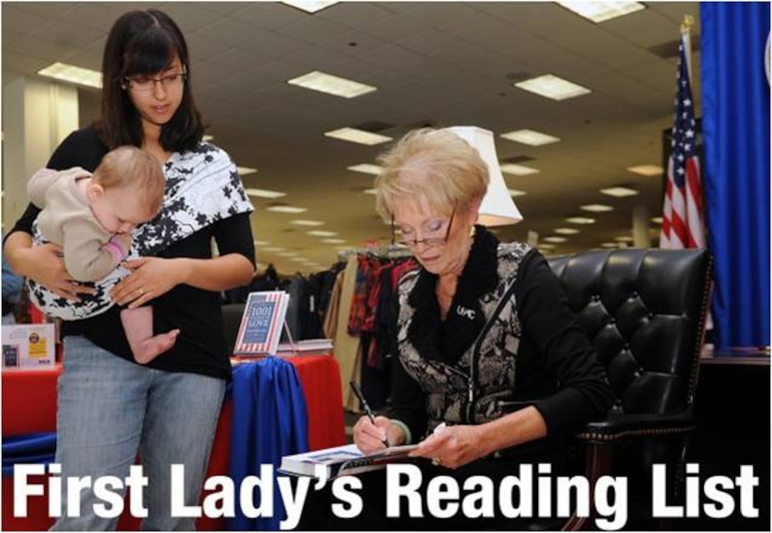 Sarah Malina, a military spouse, and her daughter Charlotte, 7 months, wait as Bonnie Amos, wife of the Commandant of the Marine Corps Gen. James F. Amos, signs their book during the book signing for the “First Lady of the Marine Corps’ Recommend Reading List.”