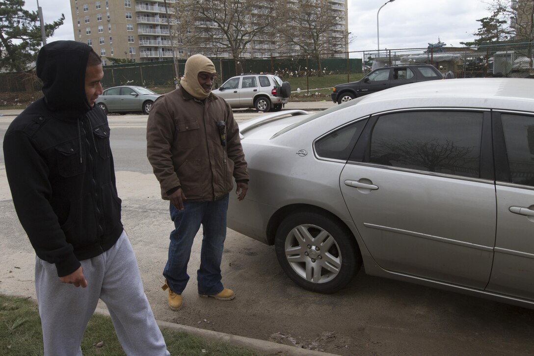 Sgt. Michael F. Blake, a motor transportation clerk with 1st Marine Corps District, shows Sgt. Julian Ranas, 1MCD’s enhanced marketing vehicle driver, how one his vehicles was pushed from the curb and took on two to four feet of water when Hurricane Sandy struck in Far-Rockaway, N.Y. Ranas is letting Blake borrow his truck to be able to get around while he processes insurance claims.