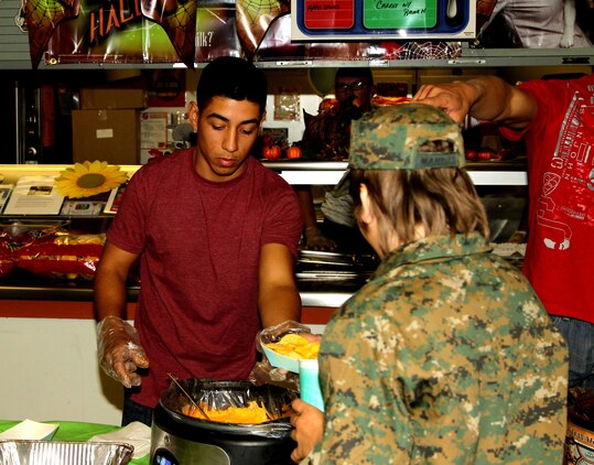 Lance Cpl. Paul Valadez, cannoneer, 3rd Battalion, 11th Marine Regiment, serves some nachos to a Freindly Hills Elementary School student at the School's Fall Festival Oct. 26. 