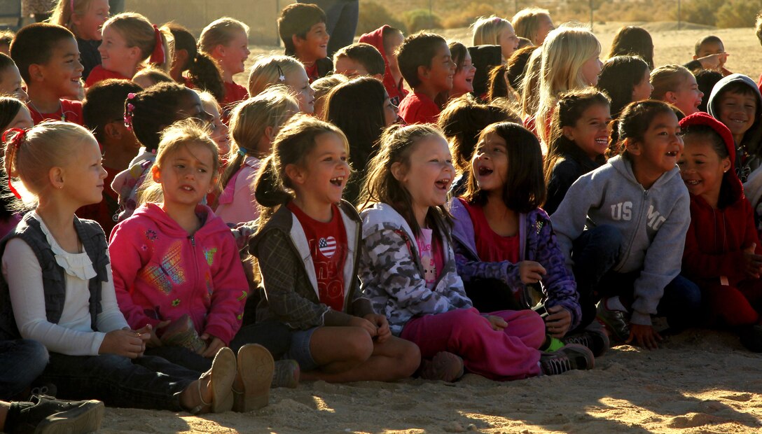The students of Condor Elementary School laugh as they watch a K-9 demonstration presented by PMO’s military working dog handlers.