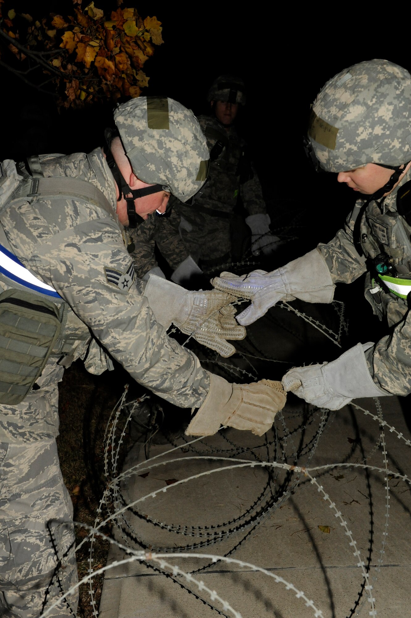 Members from 8th Security Forces Squadron place concertina wire around the wing building during Beverly Bulldog 13-1 at Kunsan Air Base, Republic of Korea, Nov. 4, 2012. The wire allows the 8th SFS to control the entry control point and keep people from entering elsewhere. (U.S. Air Force photo/Senior Airman Marcus Morris)