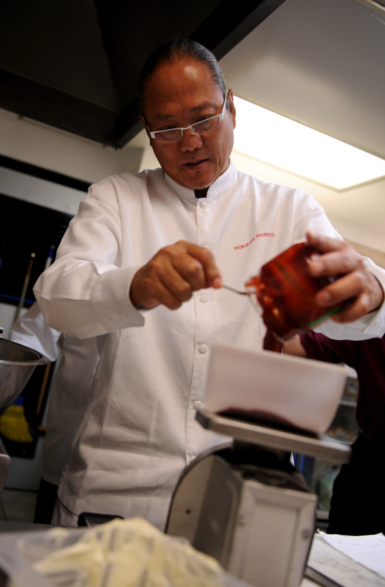 Iron Chef Masaharu Morimoto measures ingredients for a spicy sauce to be added to a shrimp tempura dish at the Emry Bowling Lanes on Kadena Air Base, Japan, Nov. 2, 2012. Two shrimp dishes were added to the bowling lane menu by the chef; one of the dishes was a spicy mustard shrimp tempura dish. Morimoto came to Kadena to meet with Airmen and their families, give sushi and sashimi demonstrations and judge Kadena?s cooking competition, held Nov. 3. (U.S. Air Force photo/Airman 1st Class Hailey R. Davis)