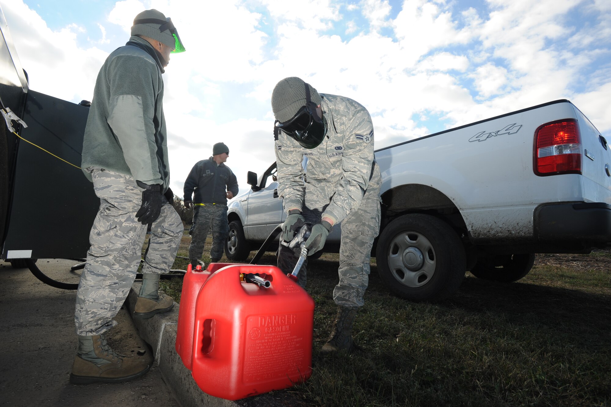 From left, Senior Airman Terence Hudson, 87th Logistics Readiness Squadron Fuels Flight fuel distributor, Senior Airman John Thomas, 87th LRSFF, and Airman 1st Class Bryan Bowers, 87th LRSFF, fuel gasoline containers Nov. 4, 2012 at Naval Weapons Station Earle, N.J. LRS Airmen are providing fuel to NWSE which lacks gasoline redibility due to Hurricane Sandy. (U.S. Air Force photo by Airman Sean Crowe/Released)